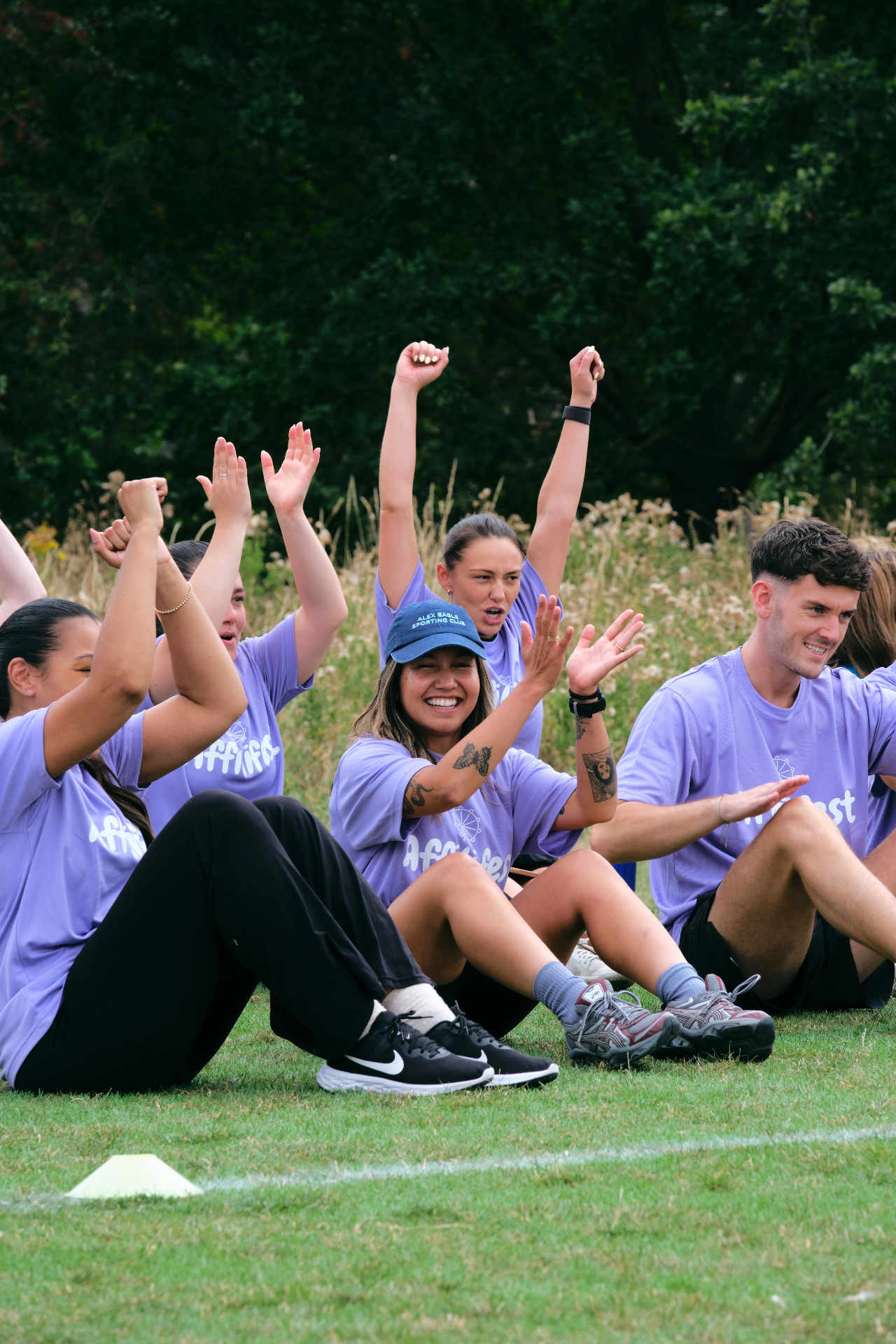 Purple team sitting on the grass cheering