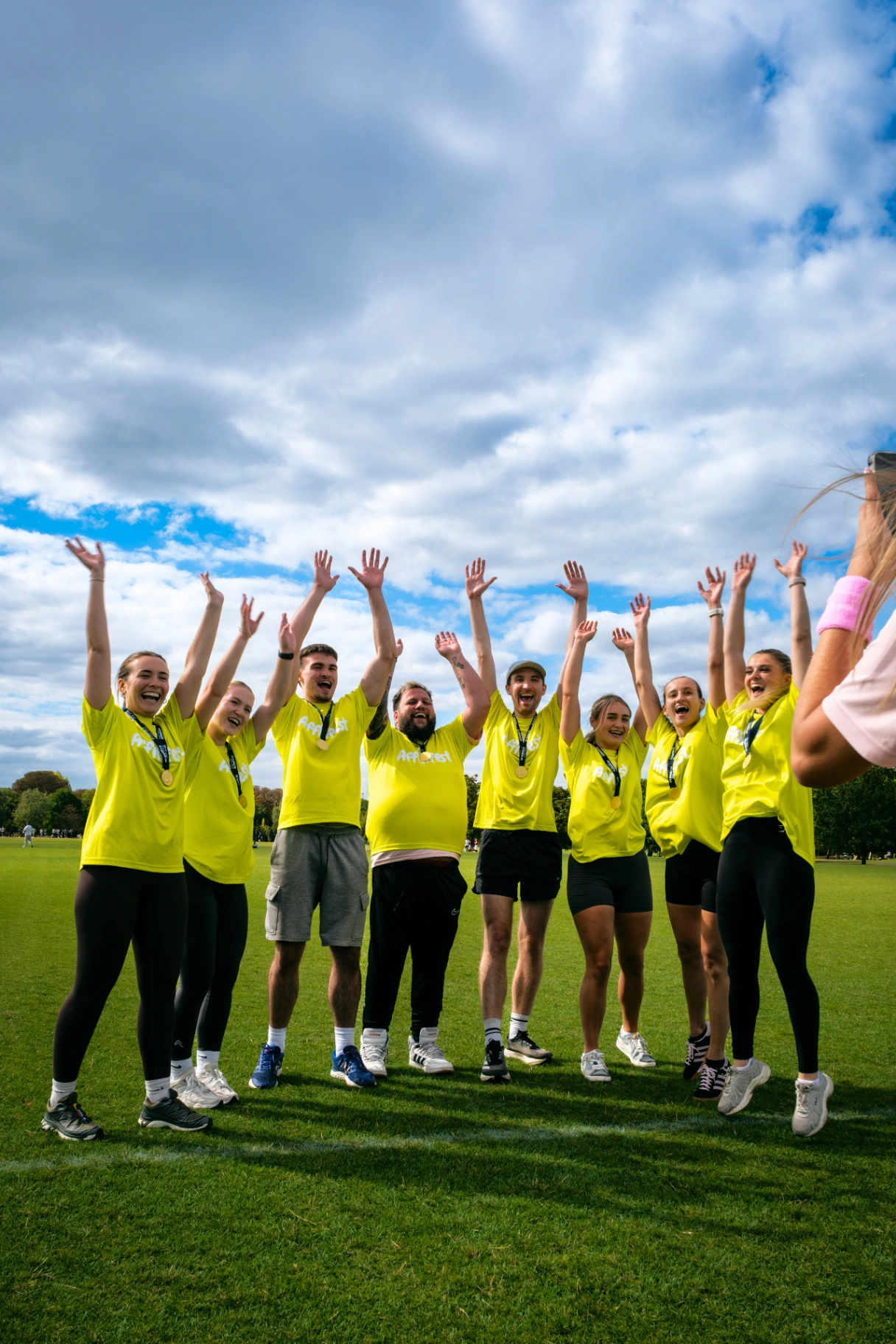 Yellow team celebrating with medals, arms in the air